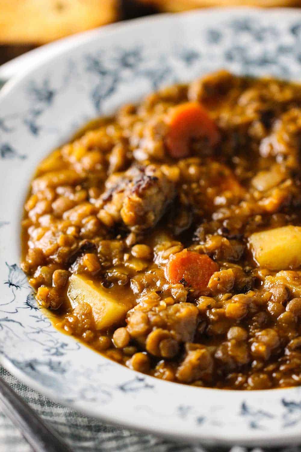 An antique soup bowl holding rustic lentil soup.