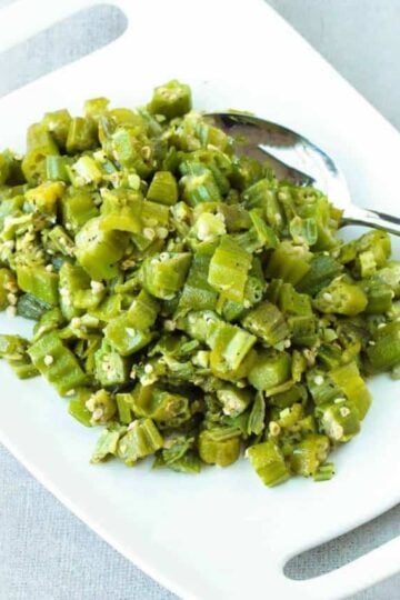 A white dish with skillet okra and garlic