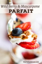 A spoon holding up a serving of fresh fruit, Mascarpone and yogurt sauce, and homemade granola.