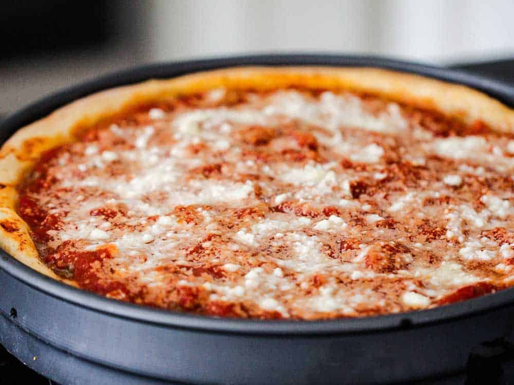 A baked deep-dish pizza in a pizza pan.