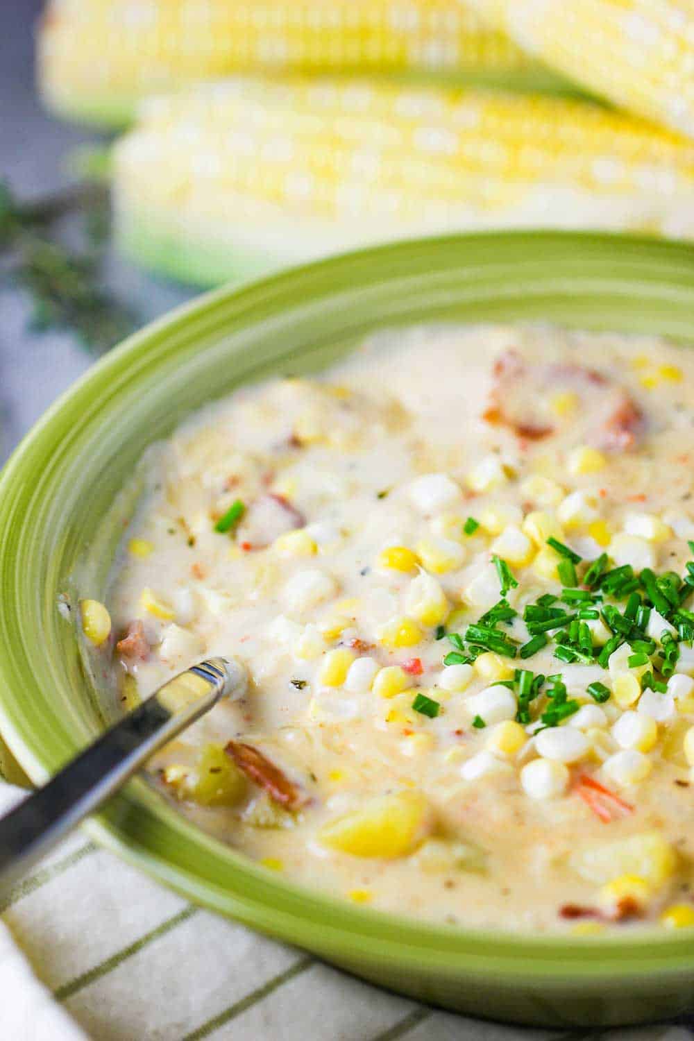A green bowl containing farm fresh corn chowder.