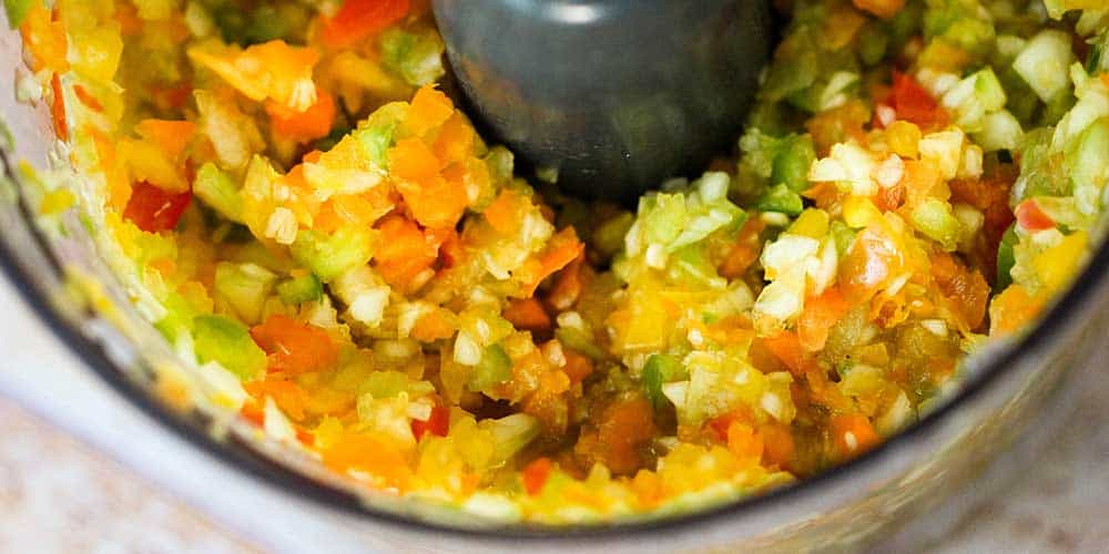 Chop the cucumber and bell peppers in a food processor.