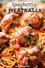 A close-up view of numerous cooked meatballs on top of spaghetti with marinar