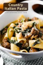 A close-up view of a white bowl holding country Italian pasta with sliced bread next to it.