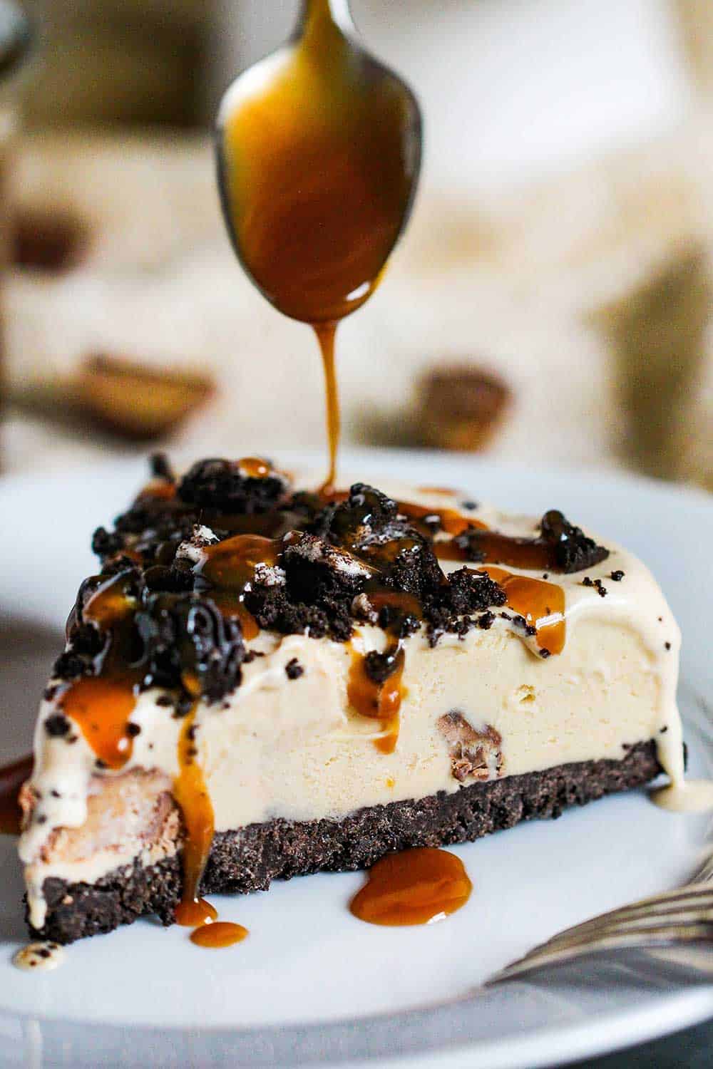 Use a spoon to drizzle homemade caramel sauce onto a slice of peanut butter cup ice cream cake.