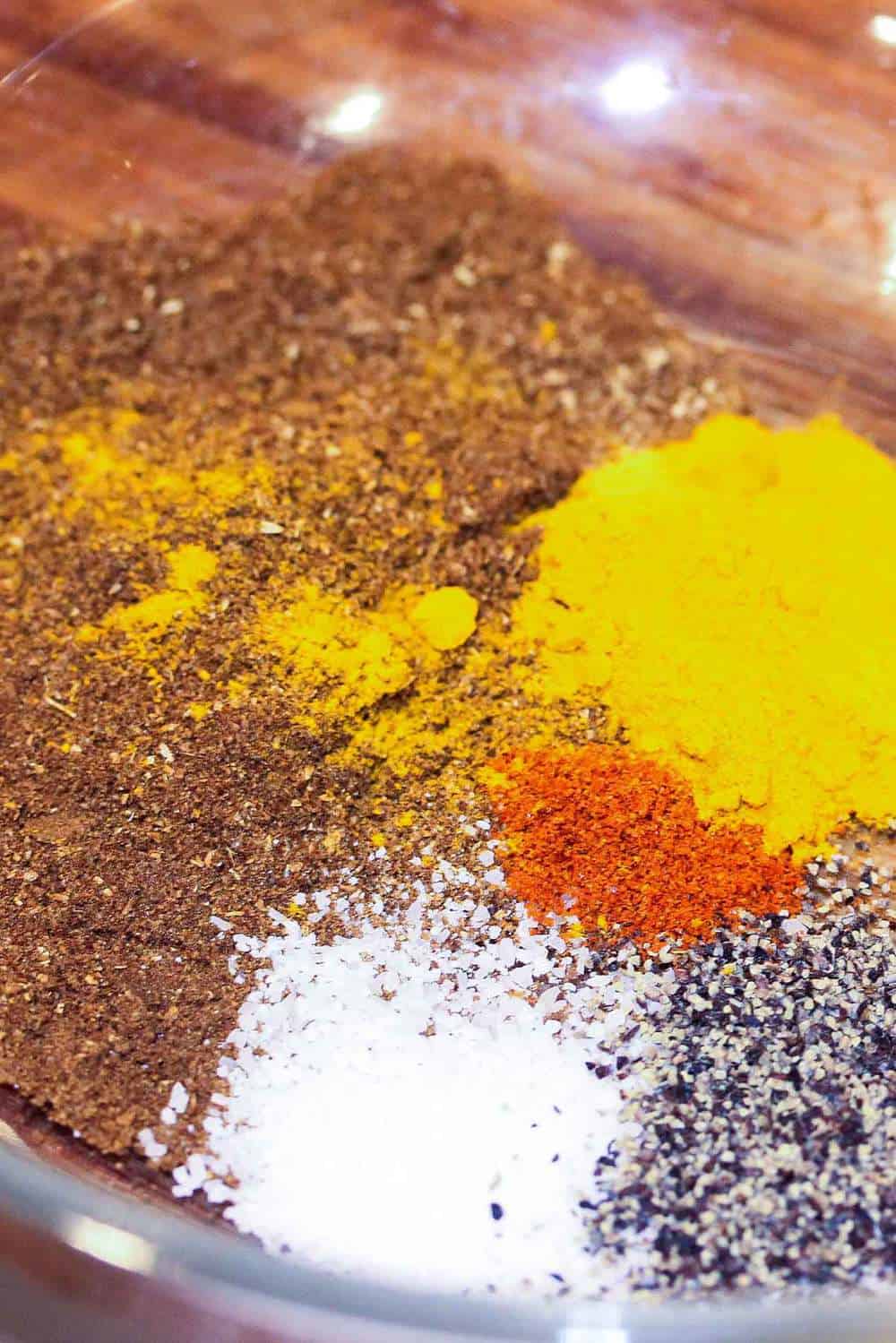 A bowl full of colorful spices for authentic curry chicken