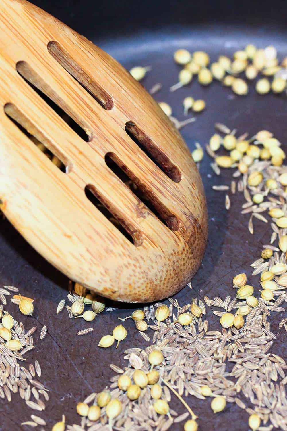 Toasting seeds in a skillet for authentic curry chicken