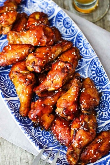 A blue platter holding a batch of teriyaki chicken wings.