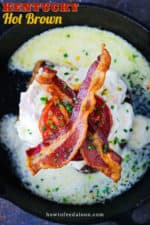 A Kentucky hot brown topped with two strips of bacon all in a cast iron skillet.