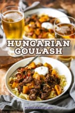 A straight-on view of two bowls of Hungarian goulash sitting next to two tall glasses of amber beer.