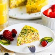 A slice of Instant Pot Cheesy Sausage and Ham Frittata on a white plate