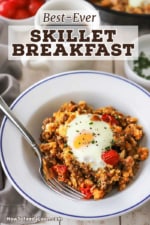An overhead view of a white bowl filled with a helping of skillet breakfast with a mug of black coffee nearby.