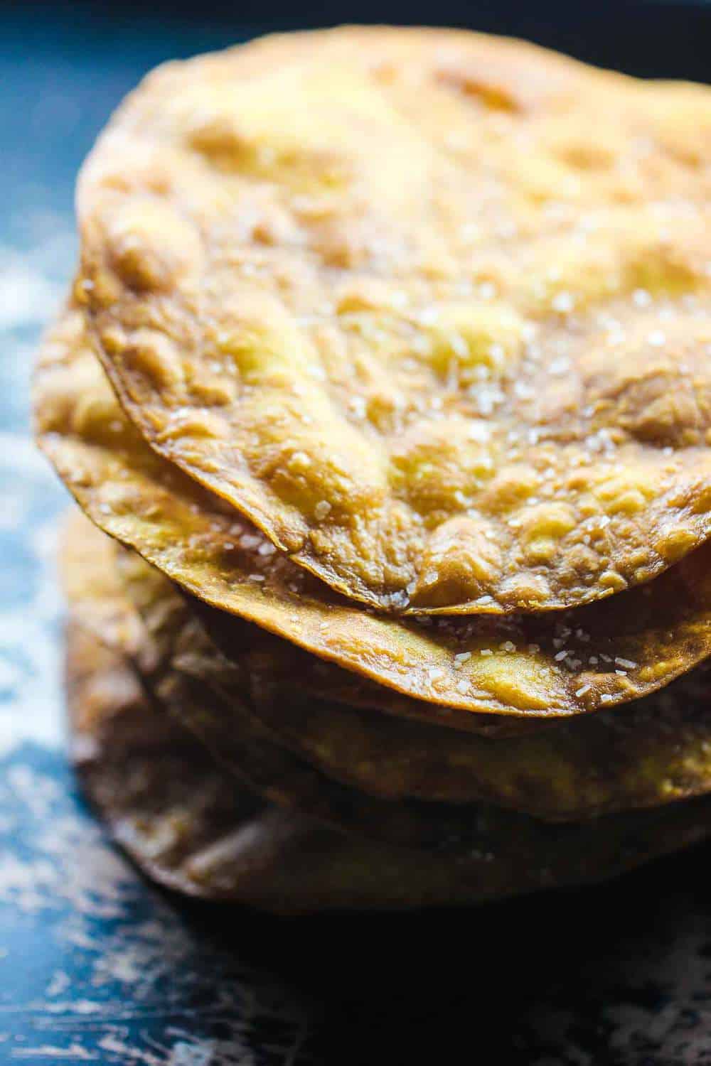 A close-up view of a stack of freshly fried corn tortillas for tostadas