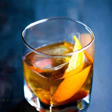 A clear glass filled with an Old Fashion Cocktail