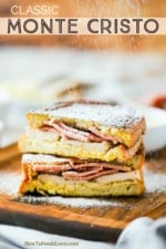 A Monte Cristo sandwich that is cut in half and stacked and powdered sugar sprinkling