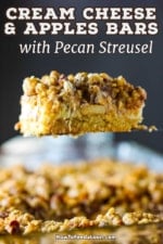 A side view of a cream cheese and apples bar being raised with a spatula from a dish filled with the dessert.