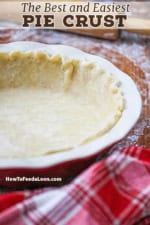 Easy pie crust dough that has been fitted into a ceramic pie dish with a floured rolling pin nearby.