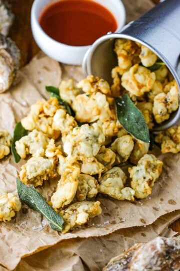 A turned-over bucket with fried oysters and clams paling out of the pale.