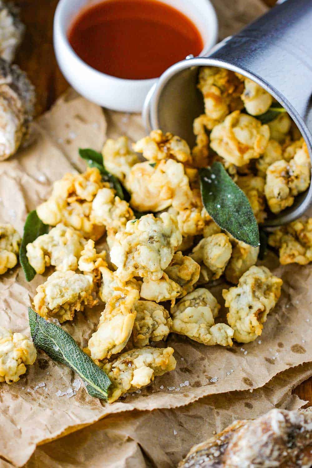 A turned-over bucket with fried oysters and clams paling out of the pale. 