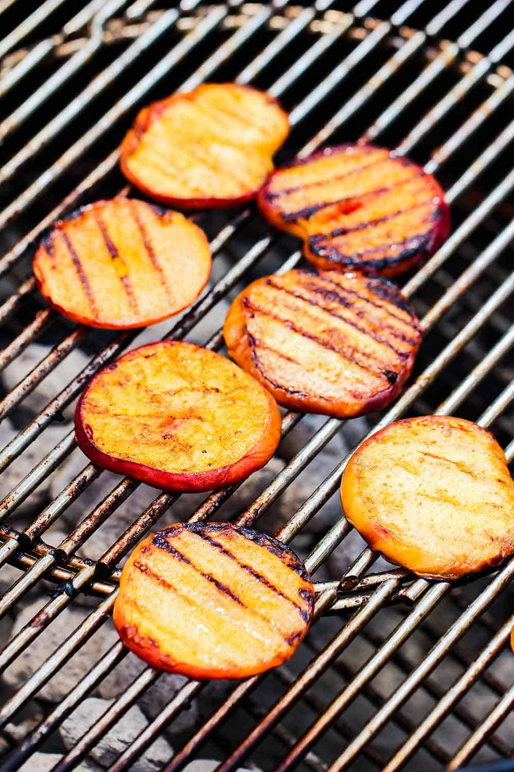 Sliced peaches on a charcoal grill
