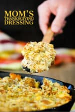 A large spoon holding a helping of Mom's Thanksgiving Dressing over of pan of the dish.