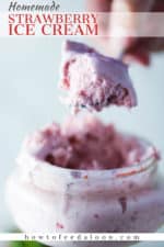 A hand holding up a spoon filled with homemade strawberry ice cream of a glass holder of the ice cream.