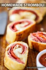 Several slices of homemade stromboli on a cutting board next to a chef's knife.