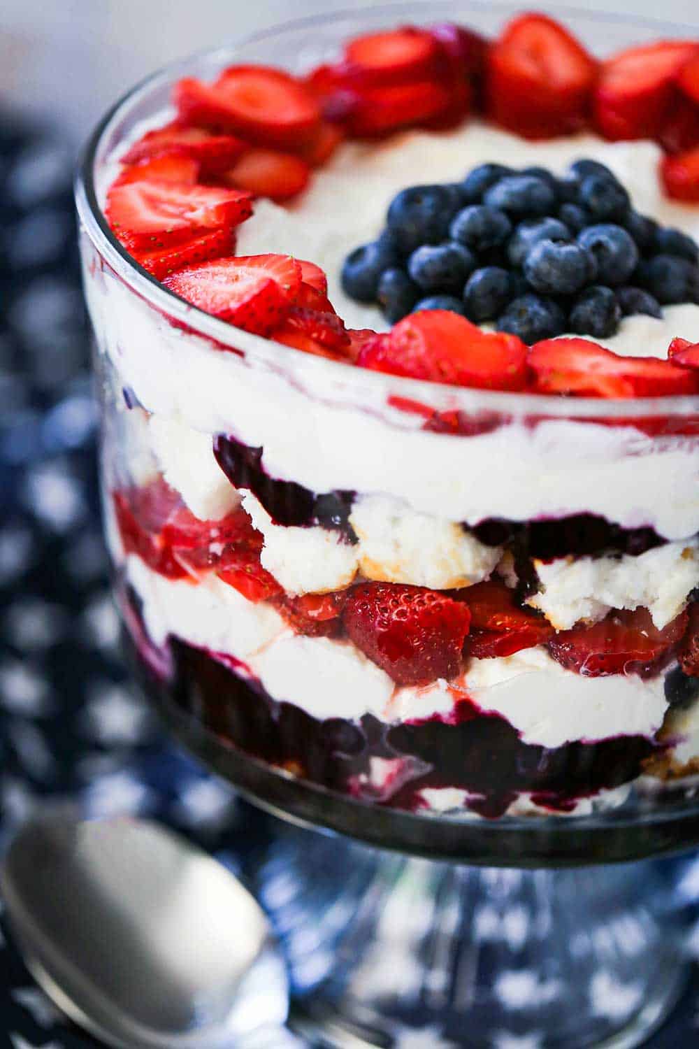 A red, white, and blue trifle sitting on a blue cloth dotted with white stars.