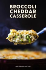 A large silver spoon lifting up a steaming helping of broccoli casserole over a dish of the same.