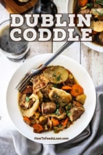 A white bowl filled with Dublin Coddle with a fork inserted in the side.