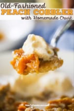 A person holding up a large spoonful of baked peach cobbler topped with vanilla ice cream.