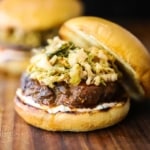 A bulgogi hamburger on a brioche bun with a layer of chili sauce mayo on the bottom and kimchi on top.