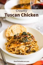A white pasta bowl filled with spaghetti topped with creamy Tuscan chicken and a slice of toasted bread on the side.