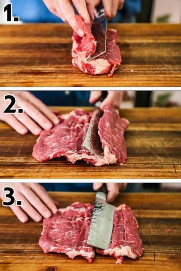 A person using a Japanese knife to butterfly a beef strip steak on a wooden cutting board.