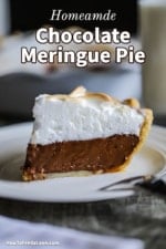 A side view of a slice of chocolate meringue pie on a dessert plate.