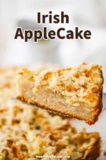 A slice of Irish apple cake being raised up the entire cake on a silver pie slicer.