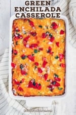 An overhead view of a nine by thirteen white casserole dish filled with a tortillas, cheese, roasted peppers, and enchilada sauce, baked until golden.