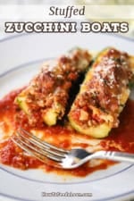 A close-up view of two stuffed zucchini boats that are resting on a bed of marinara sauce and have both been partially eaten.