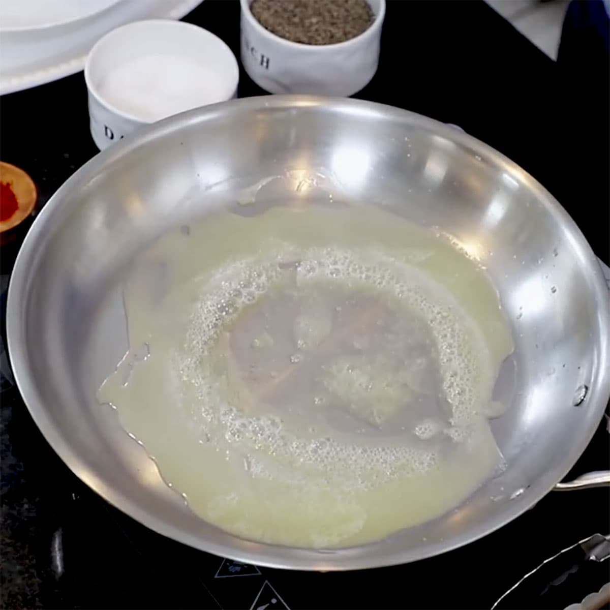 Melted butter simmering in a large silver skillet on the stove.