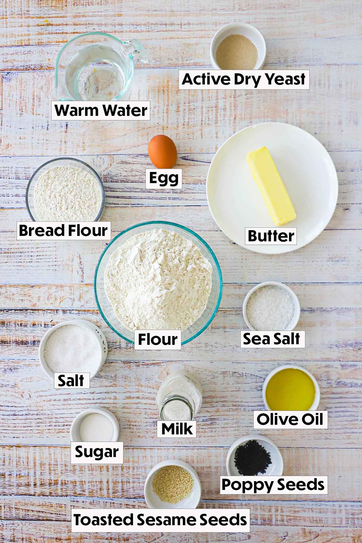 The ingredients for cloverleaf dinner rolls arranged on a white background, including all-purpose flour, yeast, sugar, salt, butter, and milk, neatly organized for easy preparation.