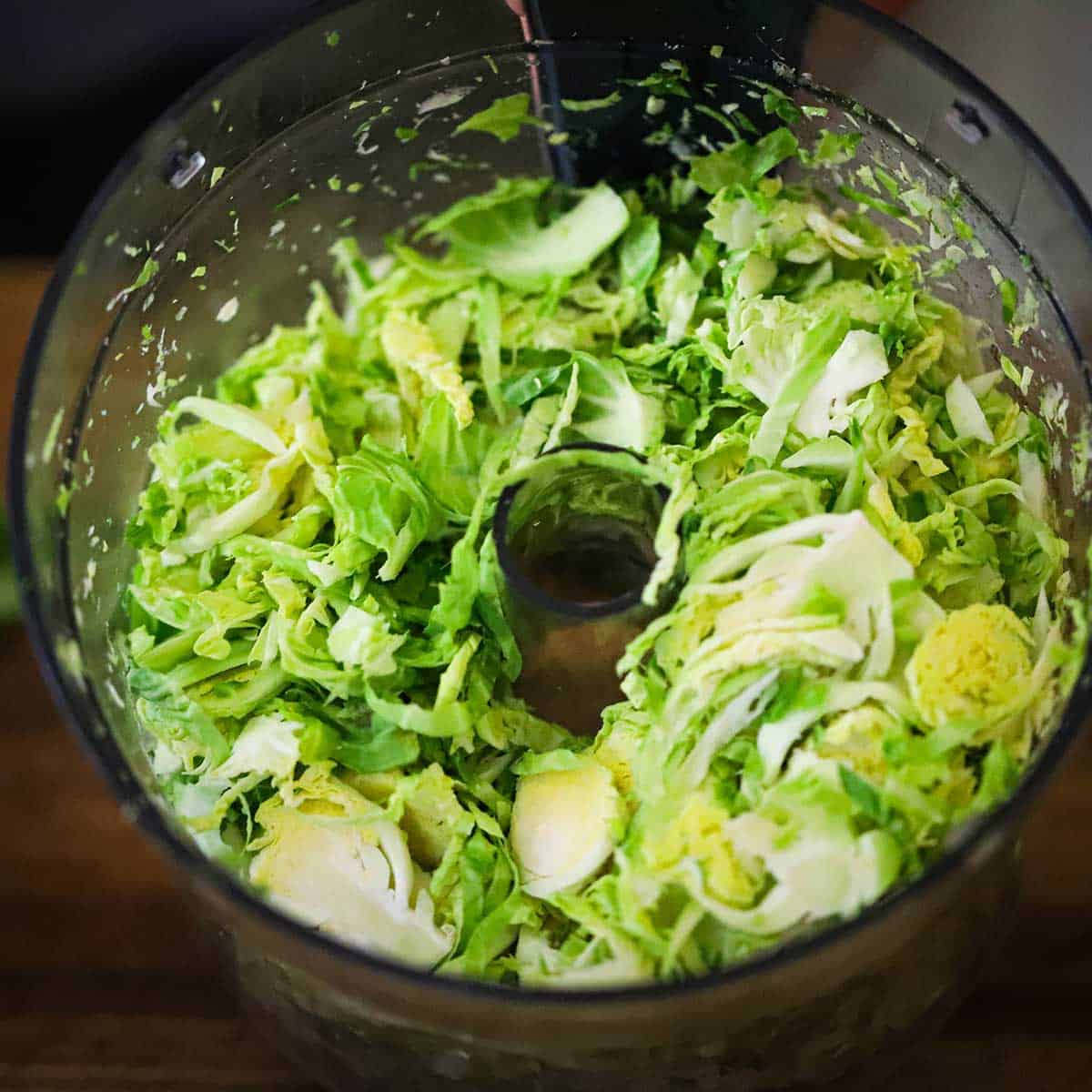 Shredded Brussels sprouts inside a food processor.