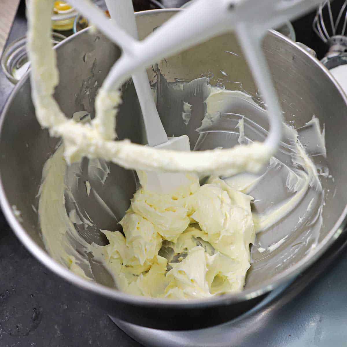 A stand mixer filled with whipped butter in it.