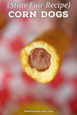 A homemade corn dog that has the end bitten off and reveals the hot dog encased in the cornbread breading.