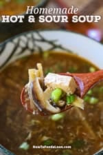 A person holding a wooden spoon filled with homemade Chinese hot and sour soup over a bowl of the same.