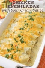 A nine by thirteen inch white casserole dish filled a row of chicken enchiladas with sour cream sauce.